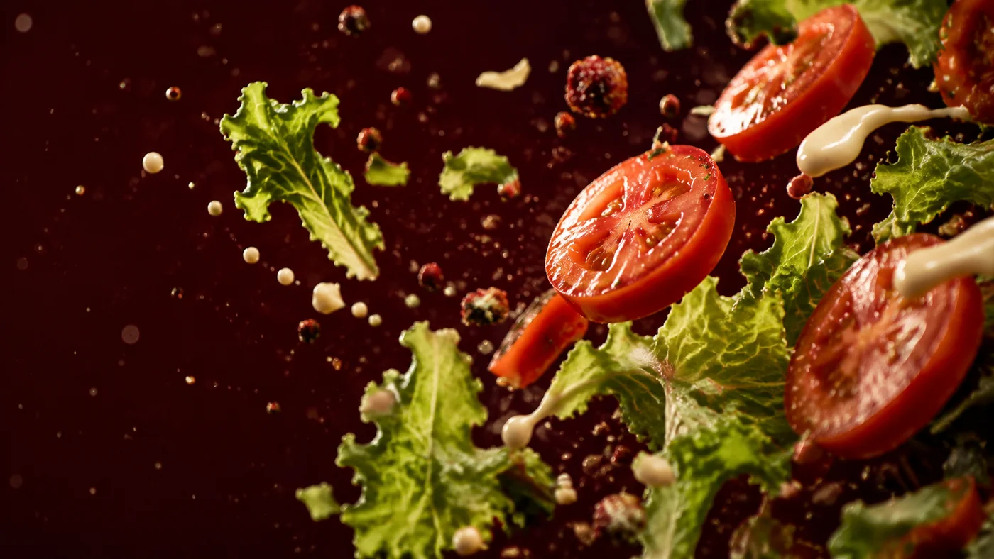 Tomate, salade et gouttes de sauce en suspension